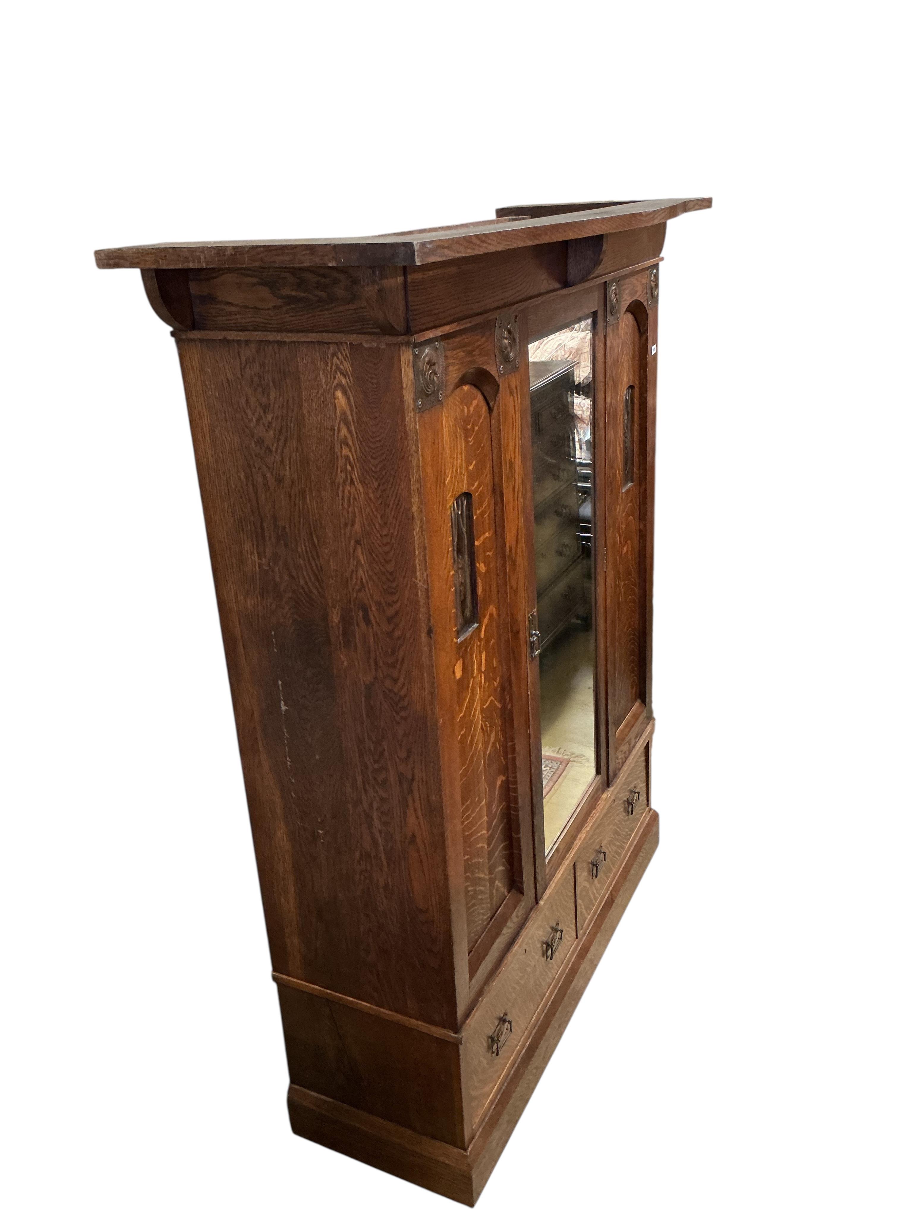 An Arts and Crafts copper mounted oak wardrobe in the manner of Shapland & Petter, width 176cm, depth 65cm, height 209cm